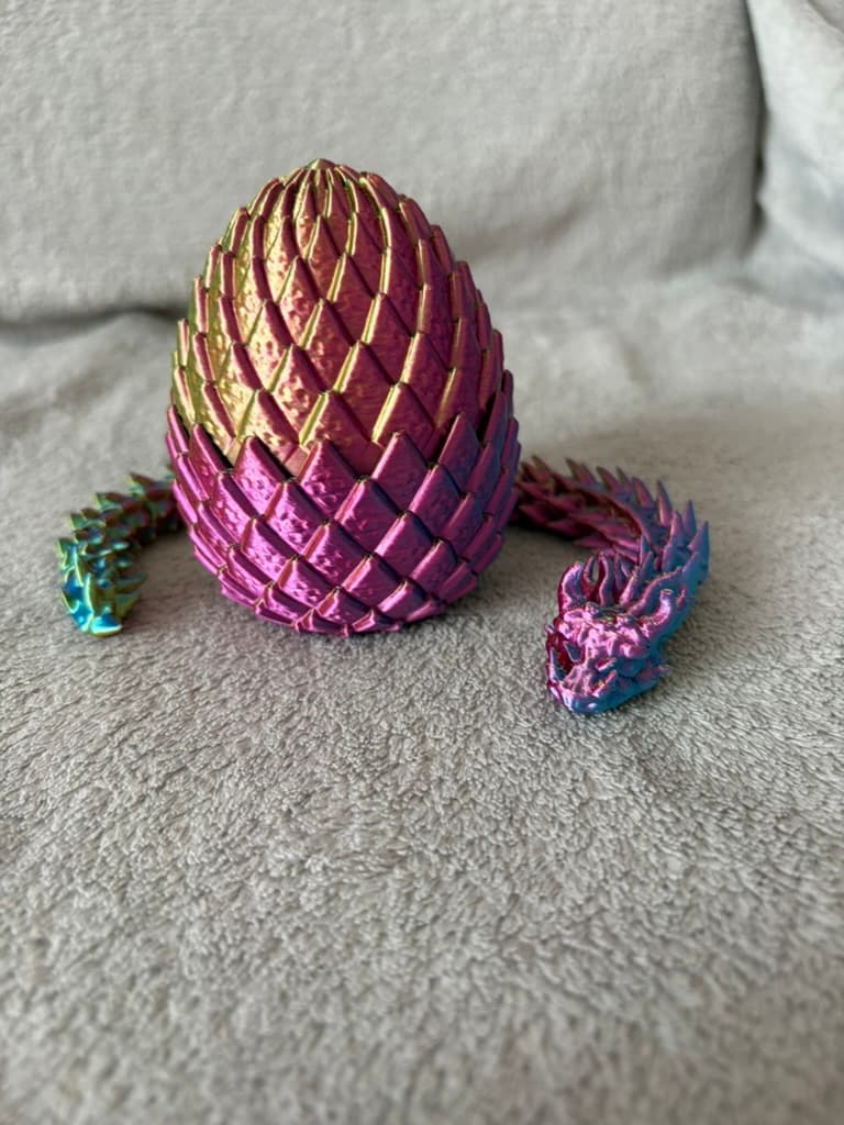 Metallisch-rosafarbenes Drachen-Ei aus Silk-PLA mit gedrucktem Drachen davor