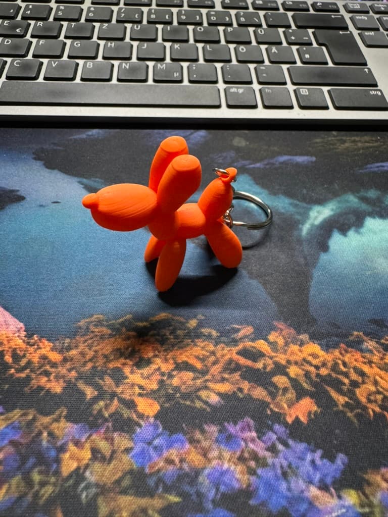 Orangefarbener Ballon-Hund als Schlüsselanhänger aus PLA